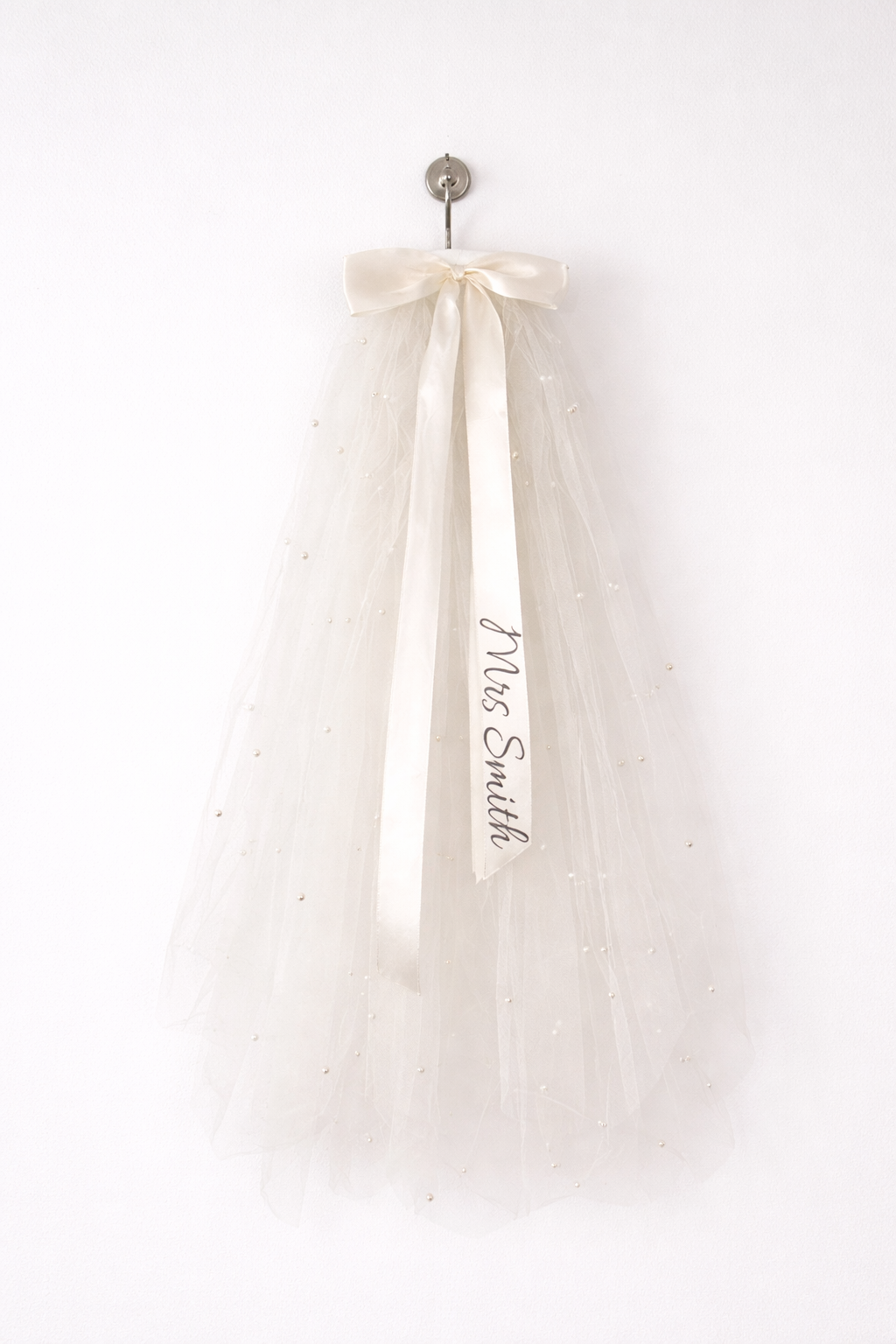 Say "I do" to a personalized veil for your hen do! 🎊 Keep it classy and sophisticated with your own message on the ribbon. With a secure comb grip, you’ll be ready to party all night!